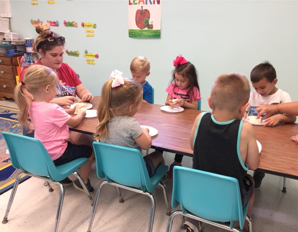 Adult and children sitting at a table eating