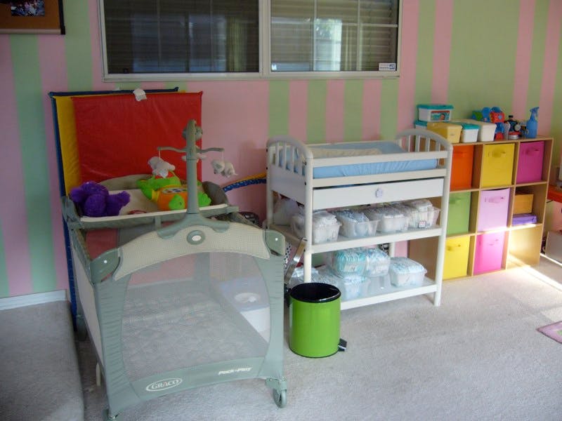 Nursery room with a crib, changing table, and storage shelves