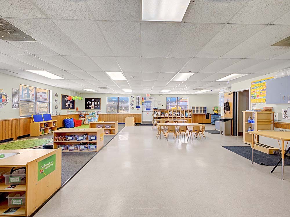 Empty colorful classroom with small tables and chairs