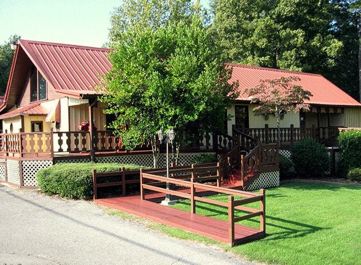 House with red roof and wooden deck