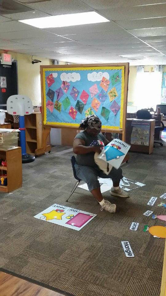 Person sitting on a chair and reading a book in a classroom