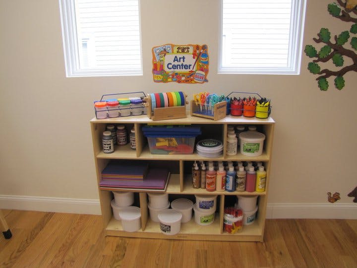 Art supplies on a wooden shelf with an "Art Center" sign above