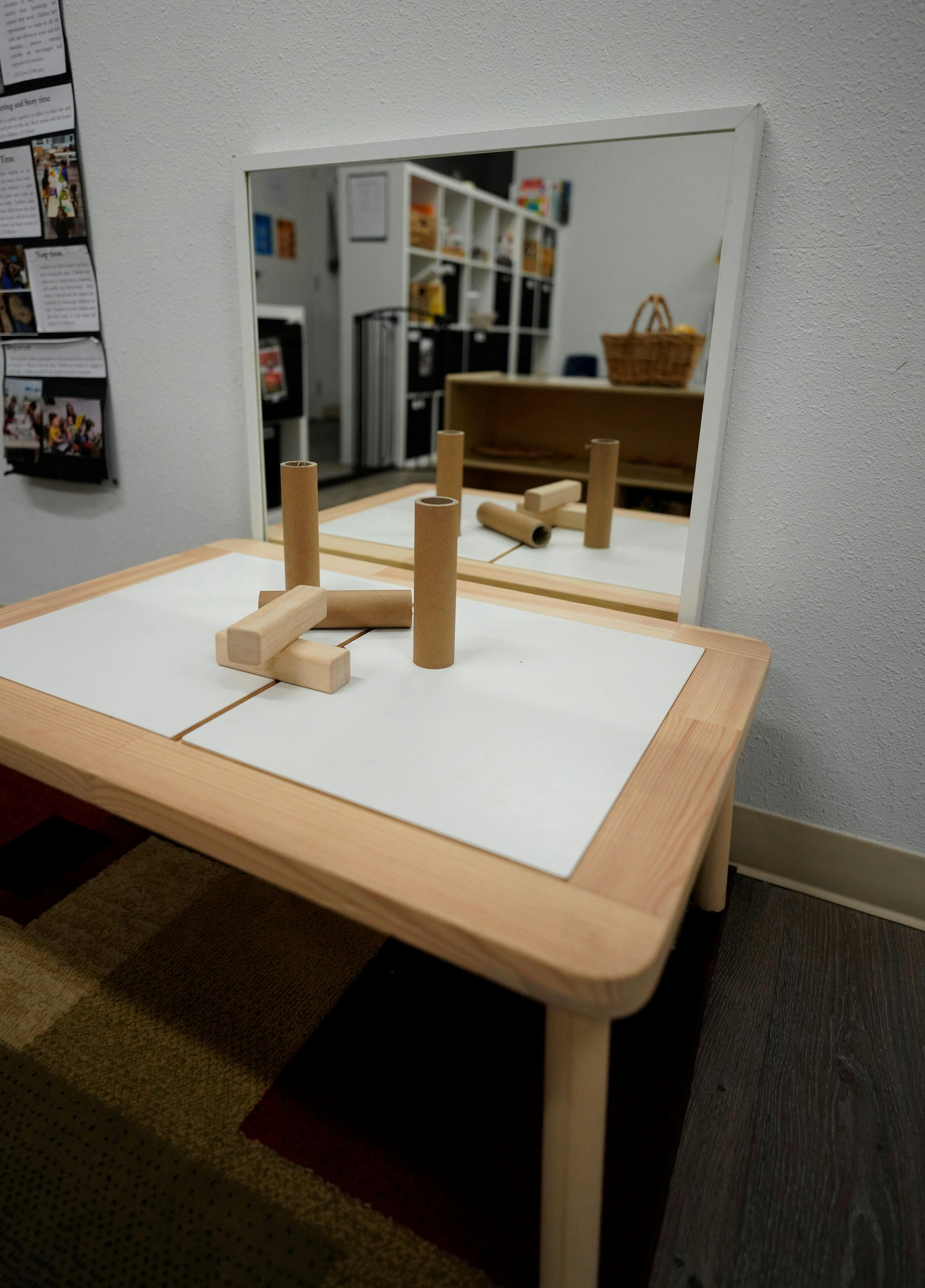 Table with cardboard tubes and wooden blocks in front of a mirror