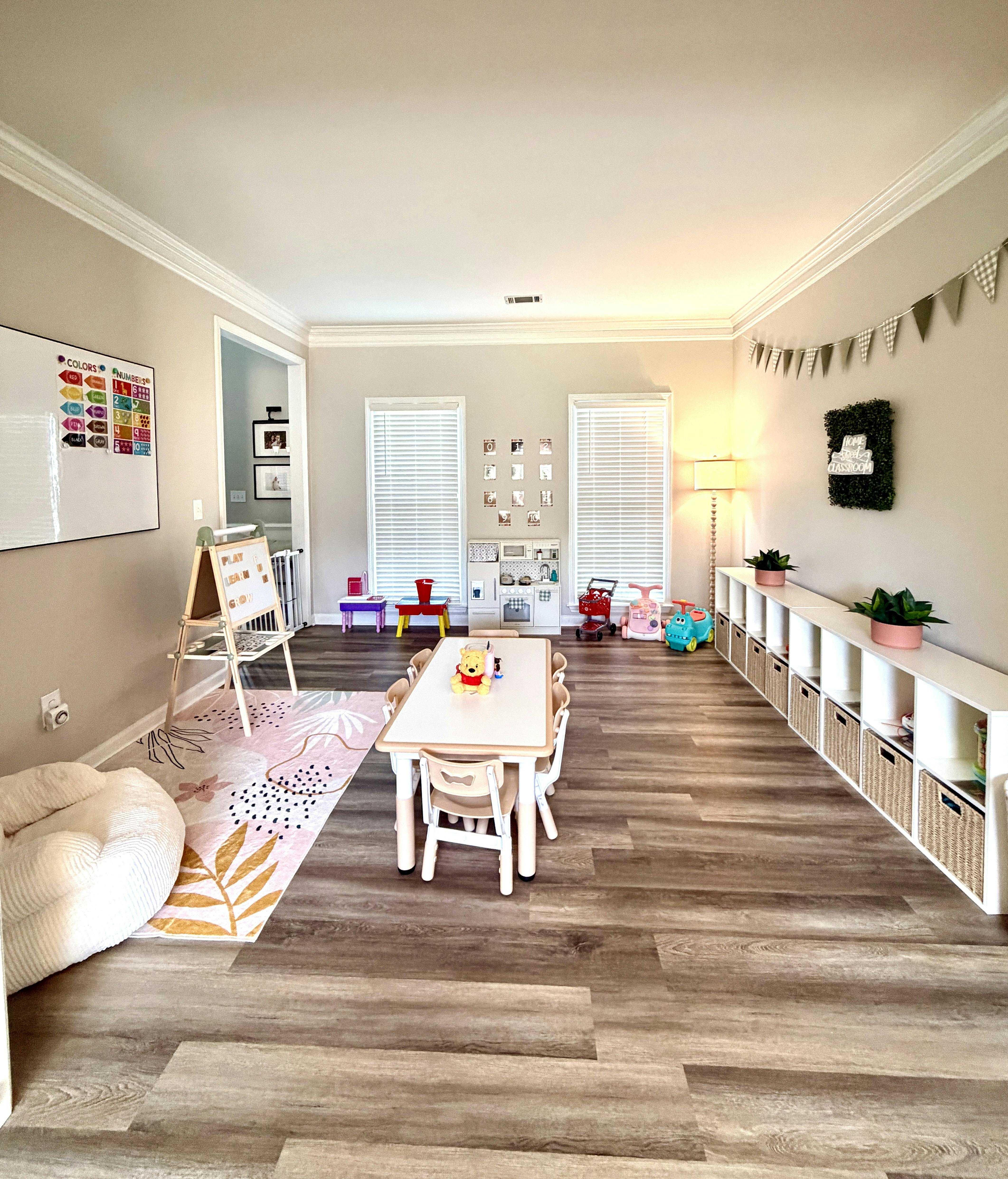 A playroom featuring a children's table, chairs, toy storage and educational art