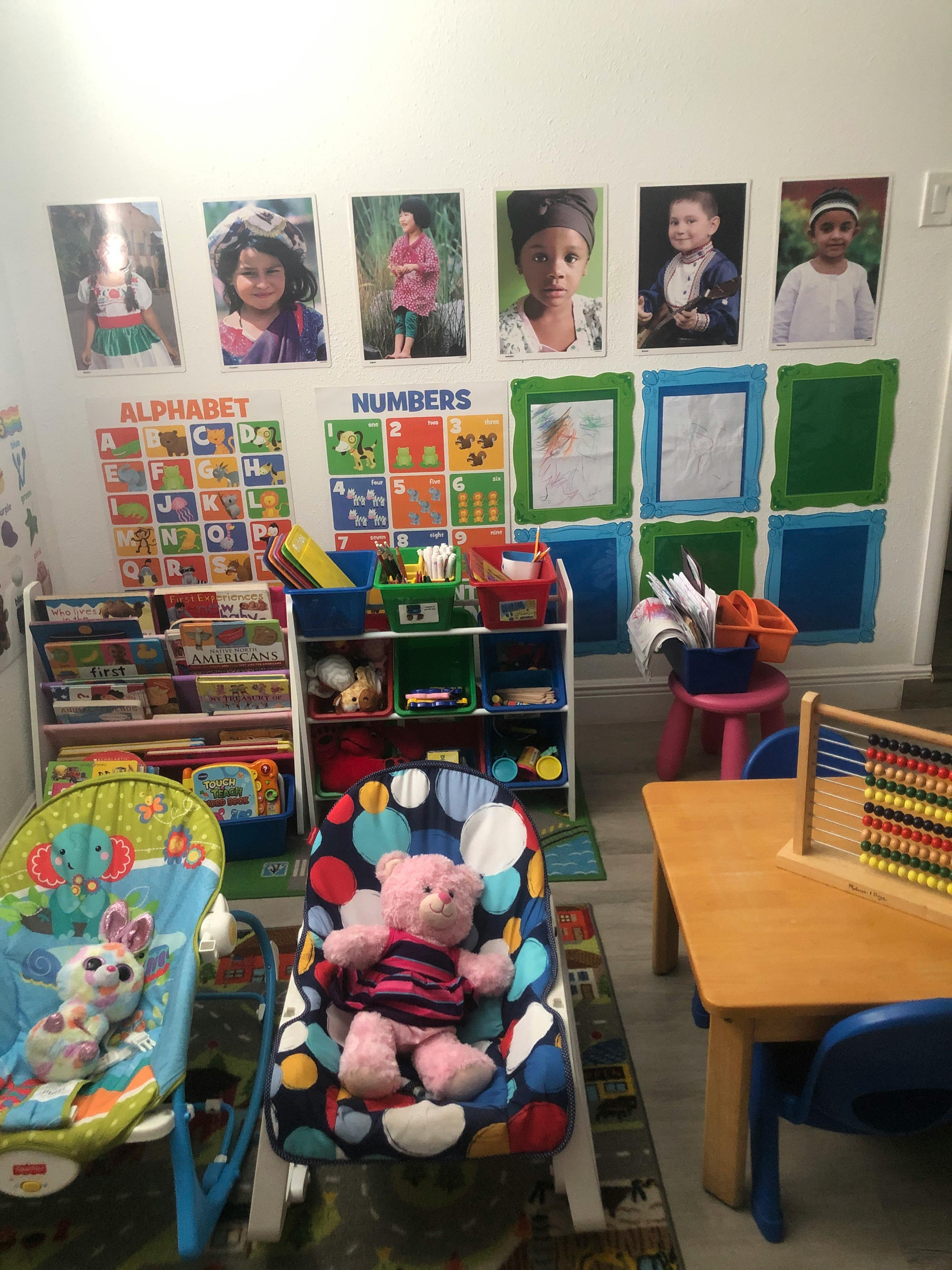 Classroom with alphabet and numbers charts, children's photos, and toys
