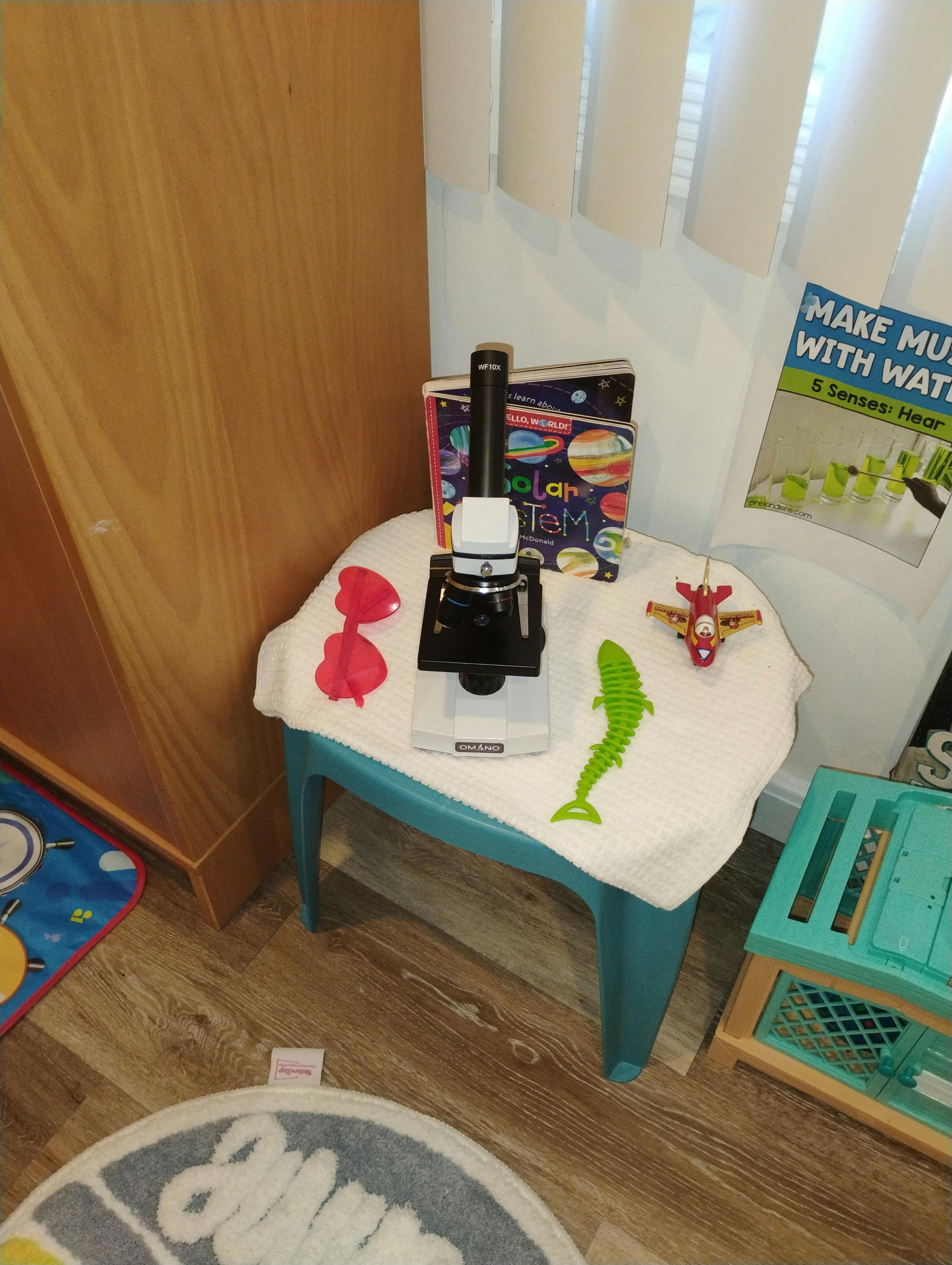 Microscope, books, toys, and sunglasses on a child's blue chair