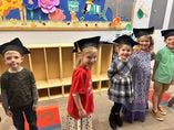Children wearing graduation caps