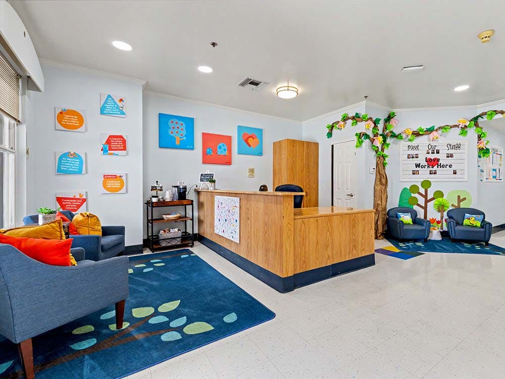 Reception area in a child-friendly space with a wooden desk and colorful decor