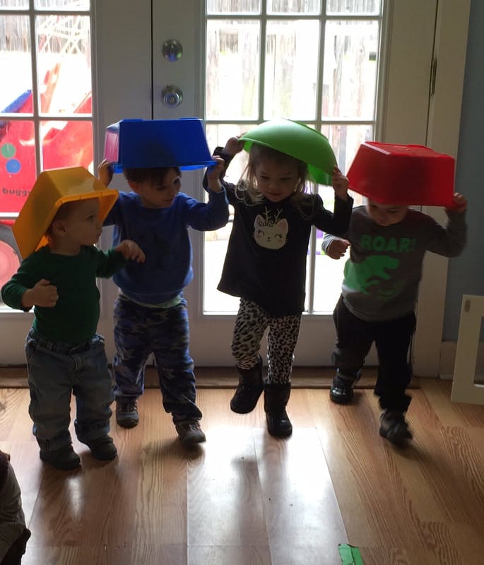 Four children with bowls on their heads