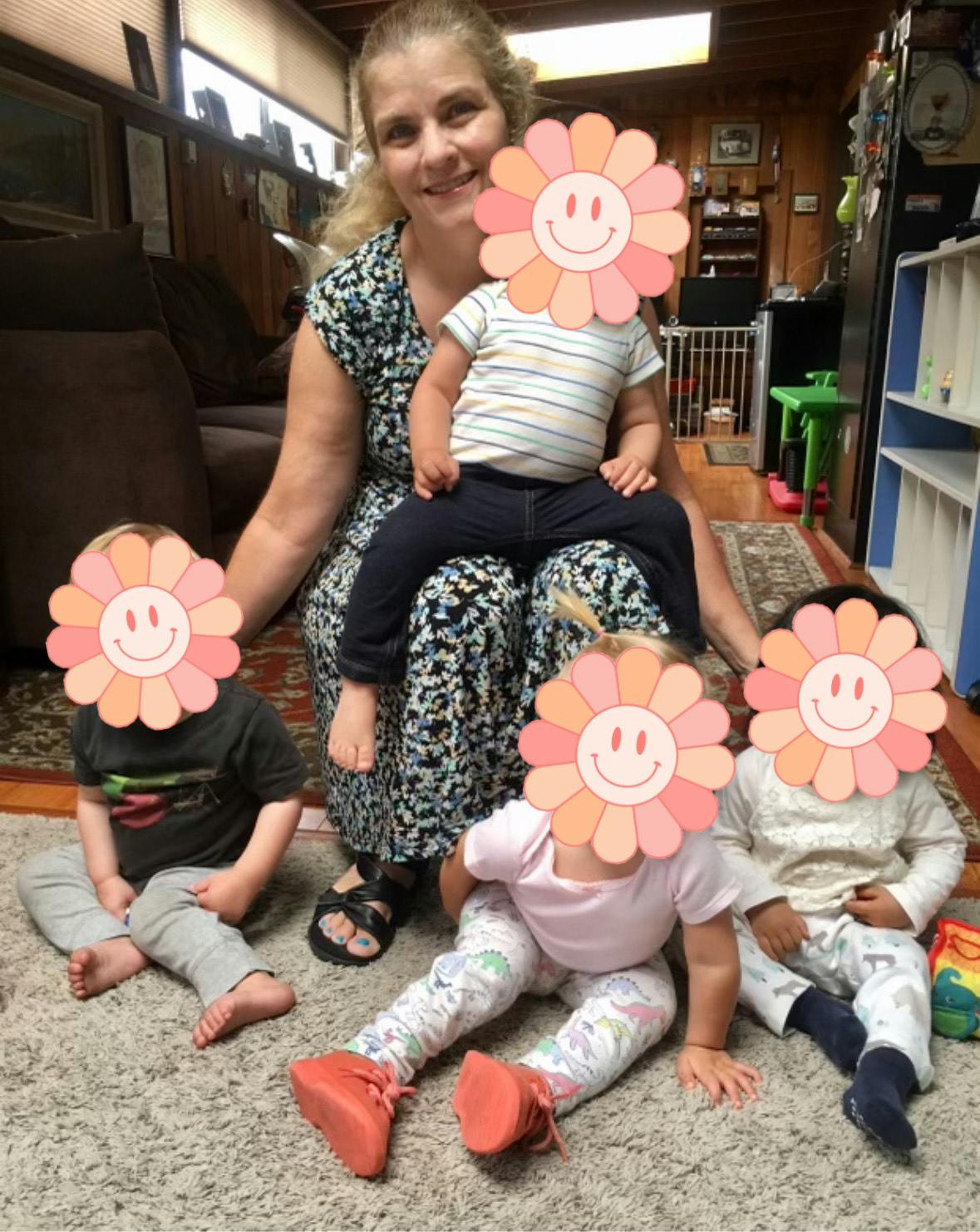 Person sitting with four children around them