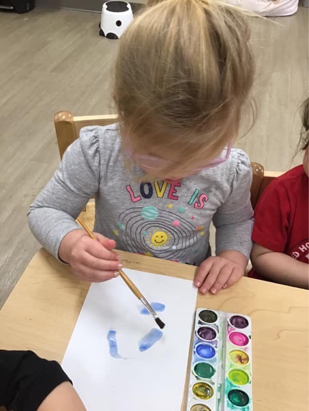 Child painting with watercolors on paper