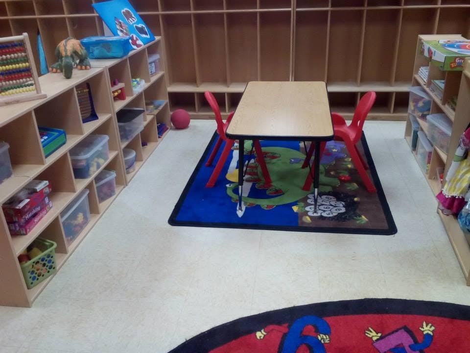 Classroom with shelves, a table, and chairs
