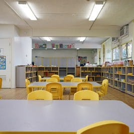 Empty classroom with yellow chairs and tables