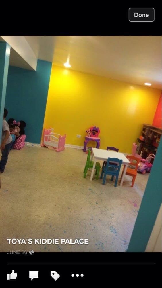 Playroom with yellow and blue walls, small table and chairs, and toys