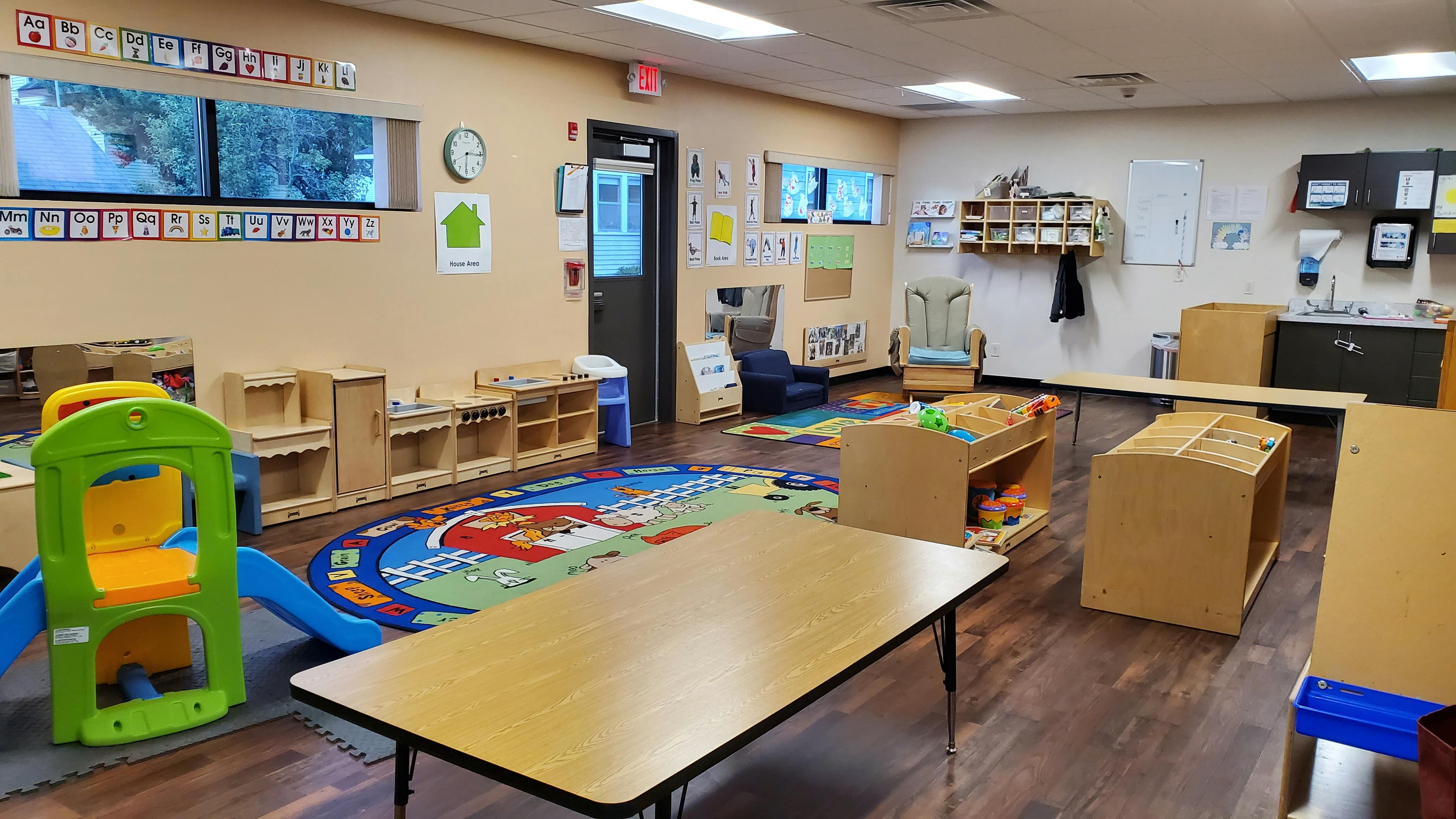 Empty classroom with tables, chairs, and play equipment