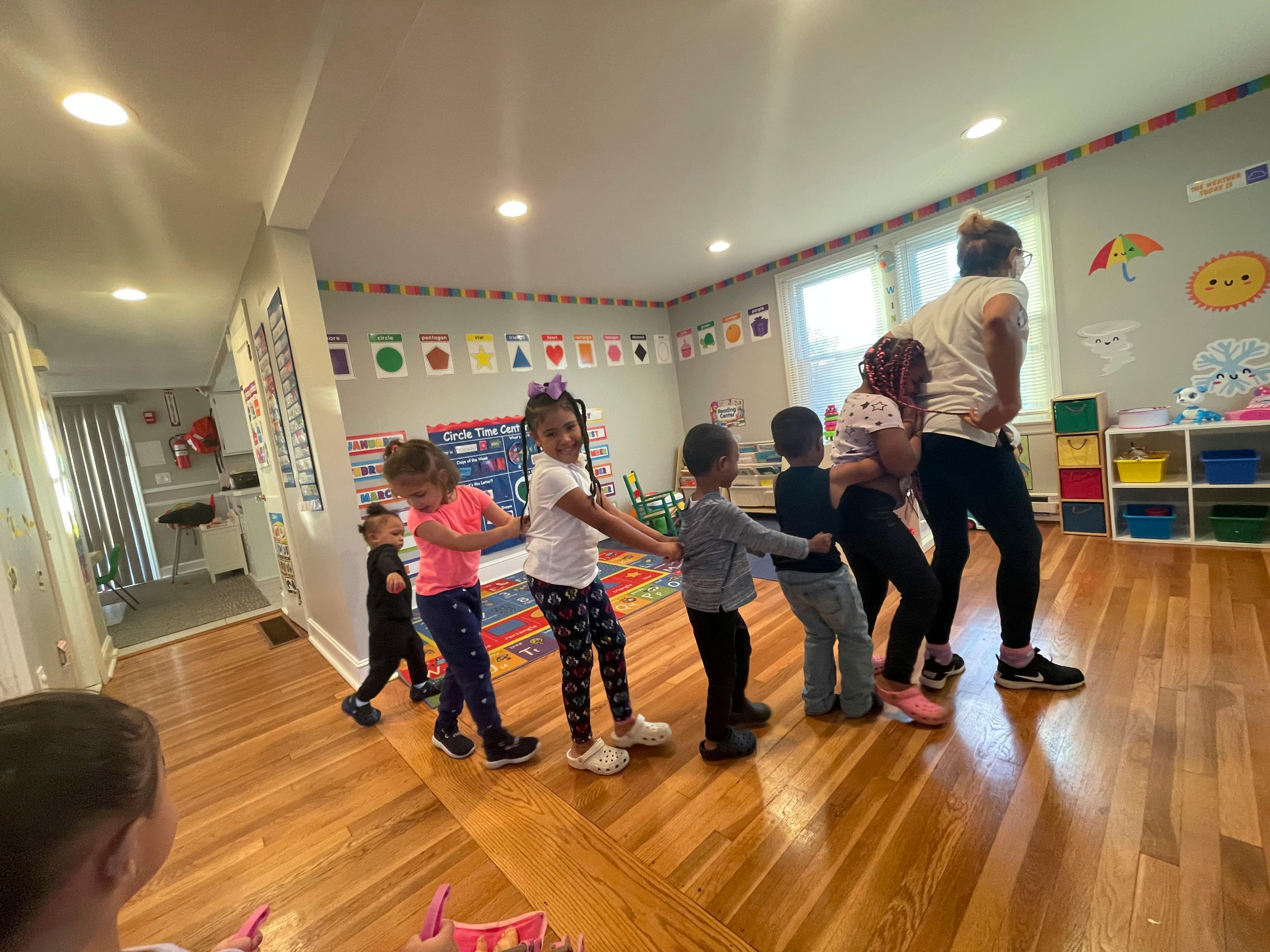 Adult and children holding hands in a line