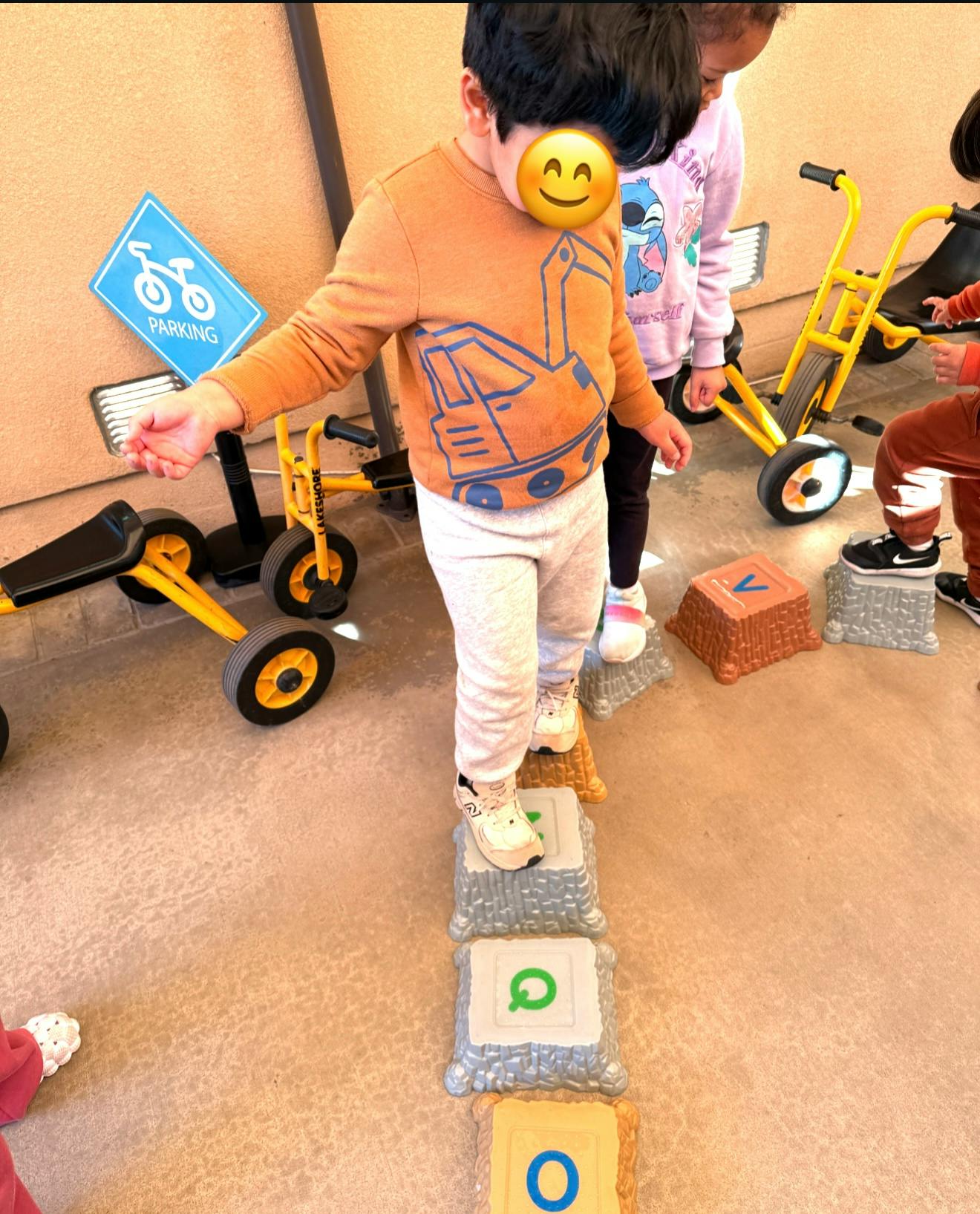Child walking on stepping stones in a play area