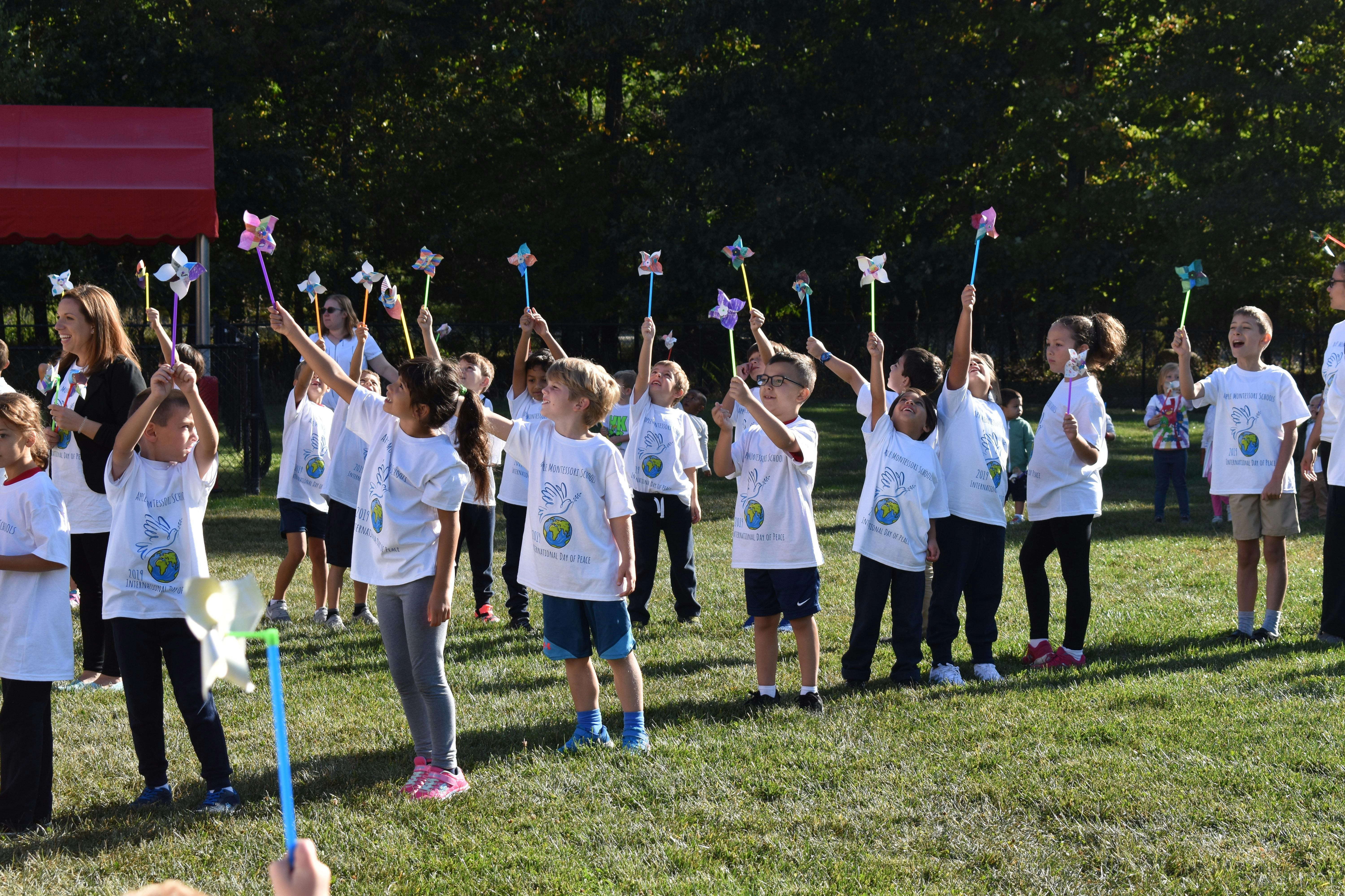 Children holding up pinwheels in a field