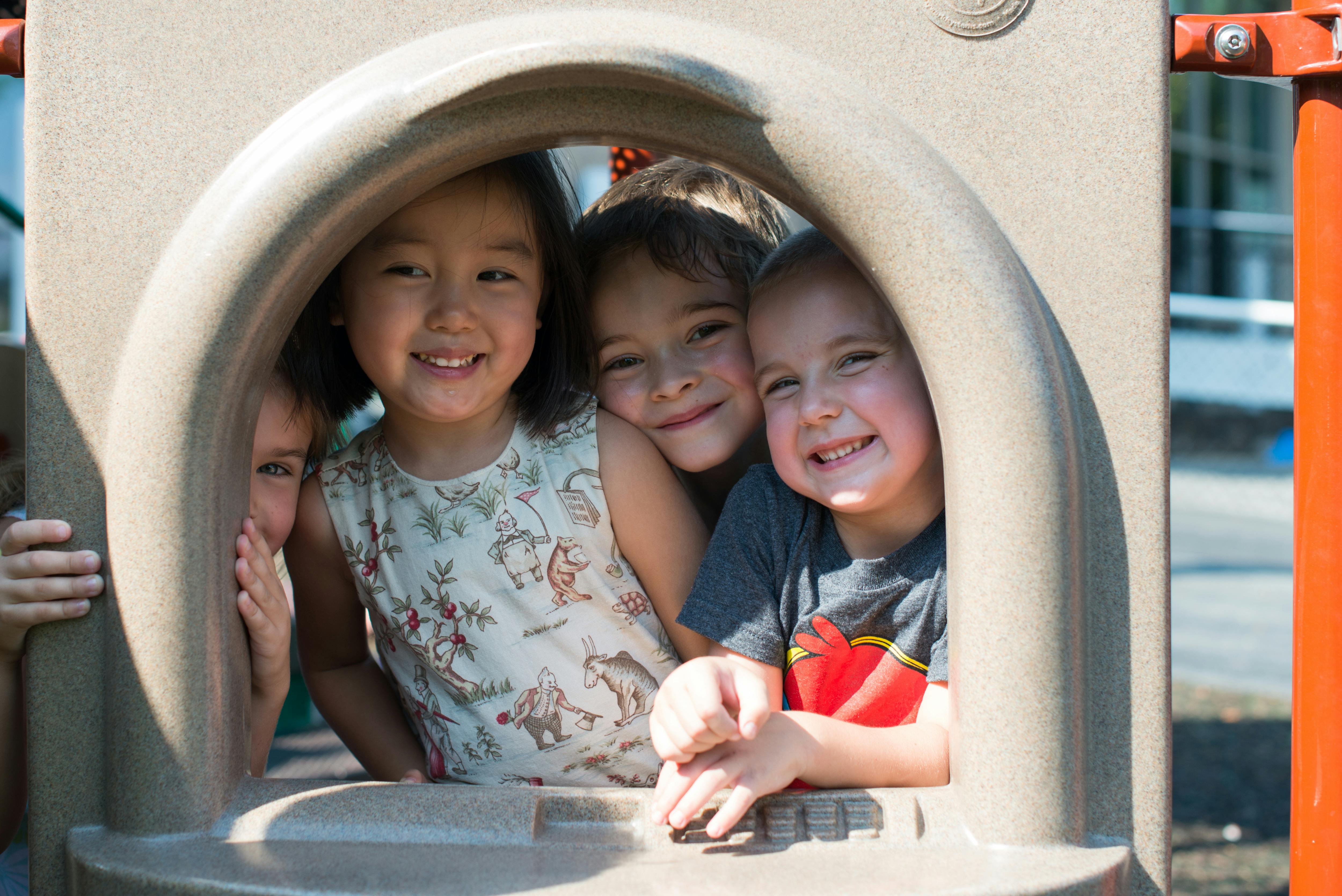 Four children looking out from a playground structure