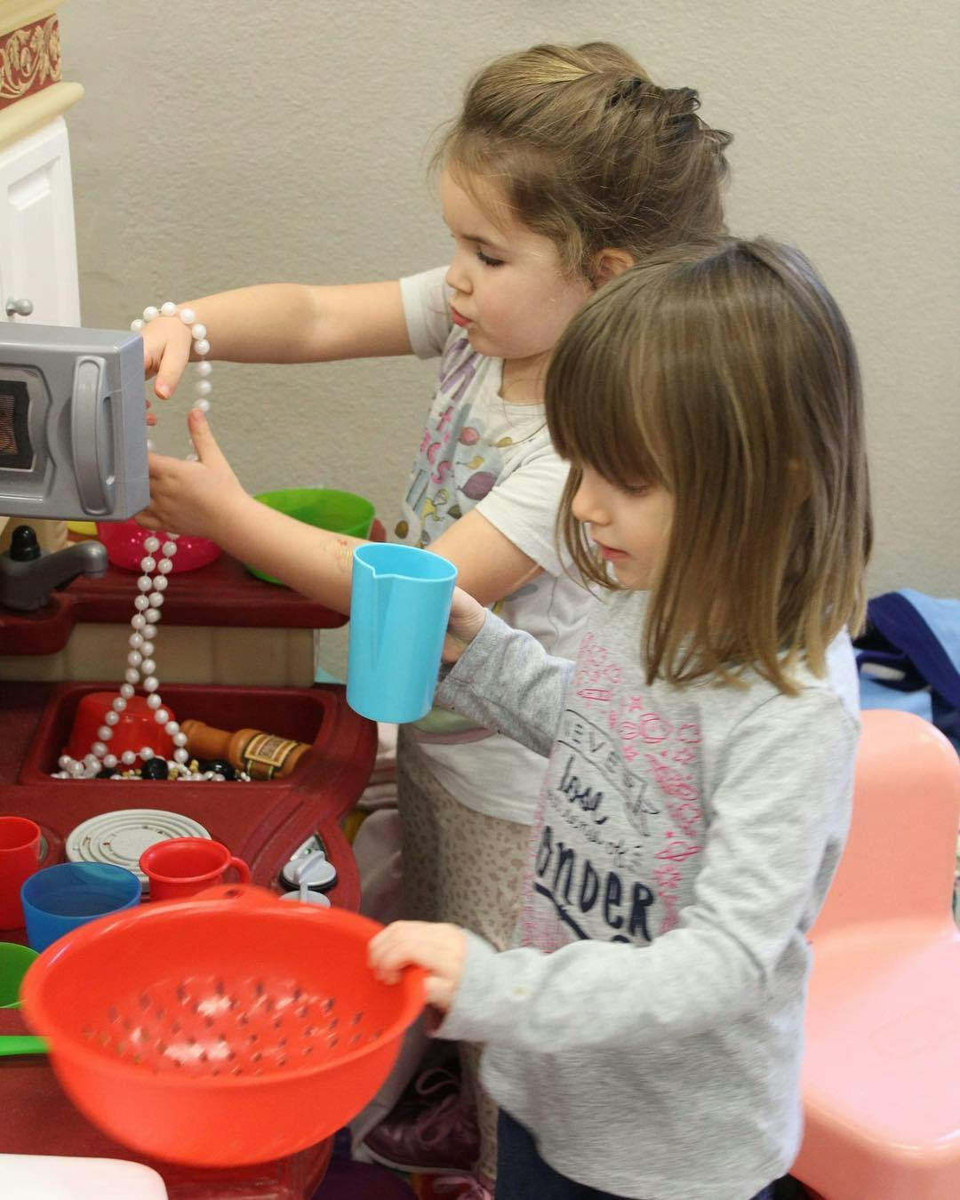 Two children playing with toy kitchen items