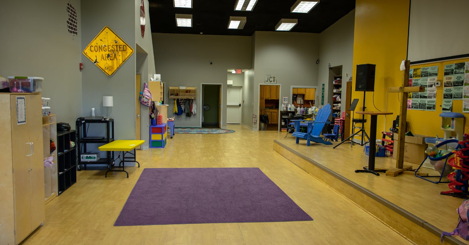 Empty room with a purple rug on a wooden floor
