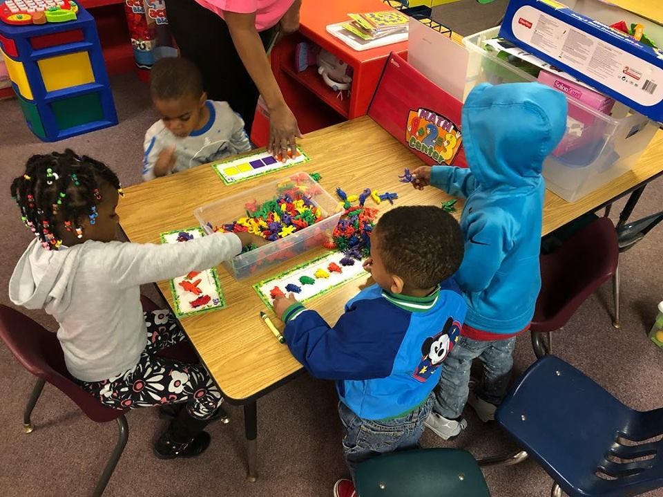 Children playing with colorful manipulatives at a table