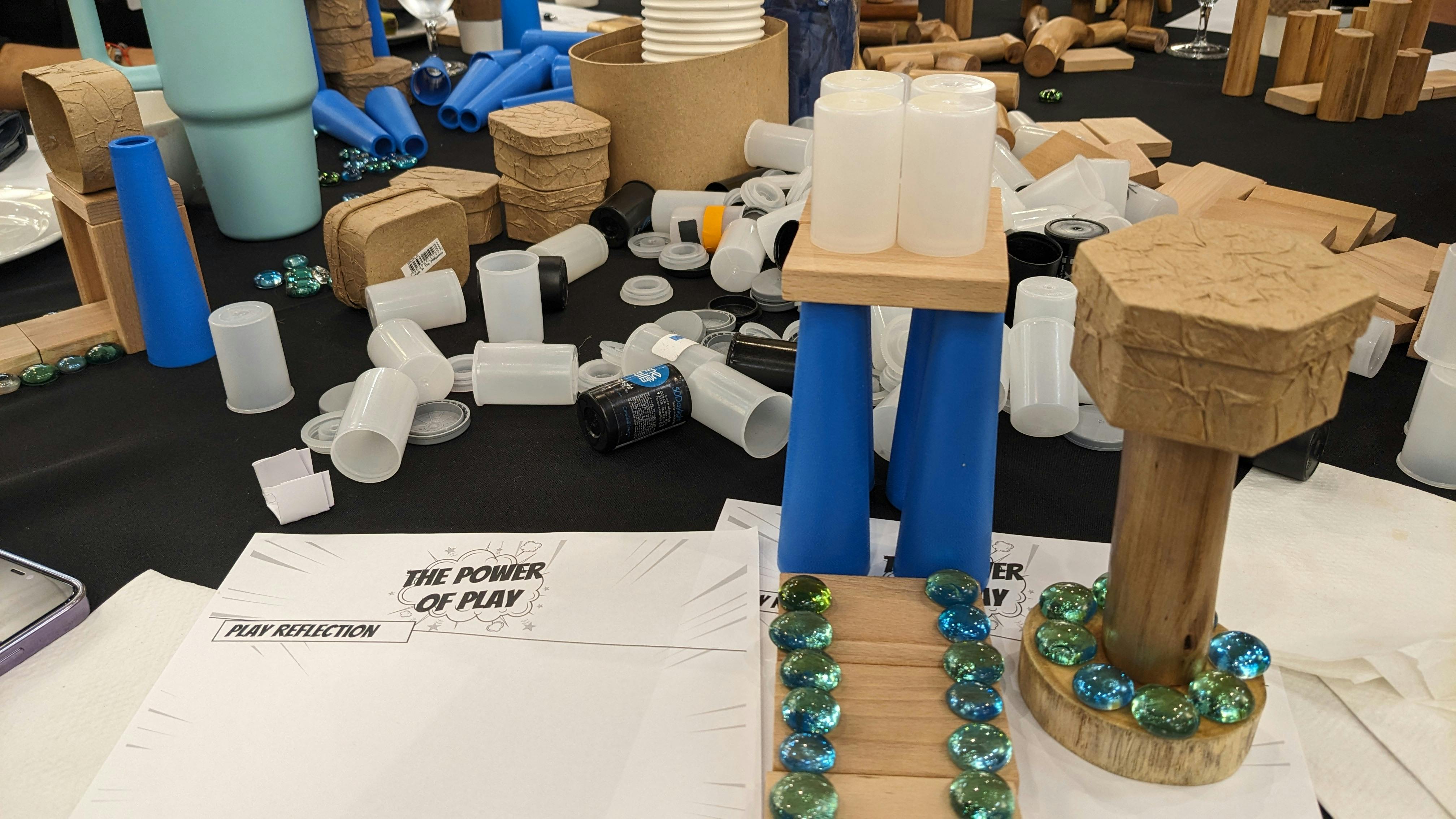 Table with various craft materials and a sign that reads "The Power of Play"