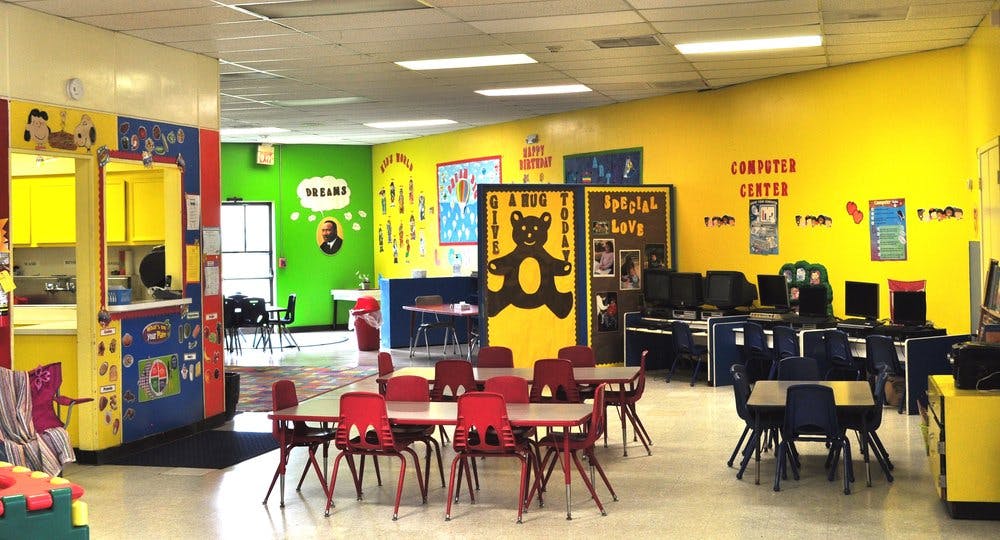 Children's classroom with tables and chairs, computer center, and colorful walls
