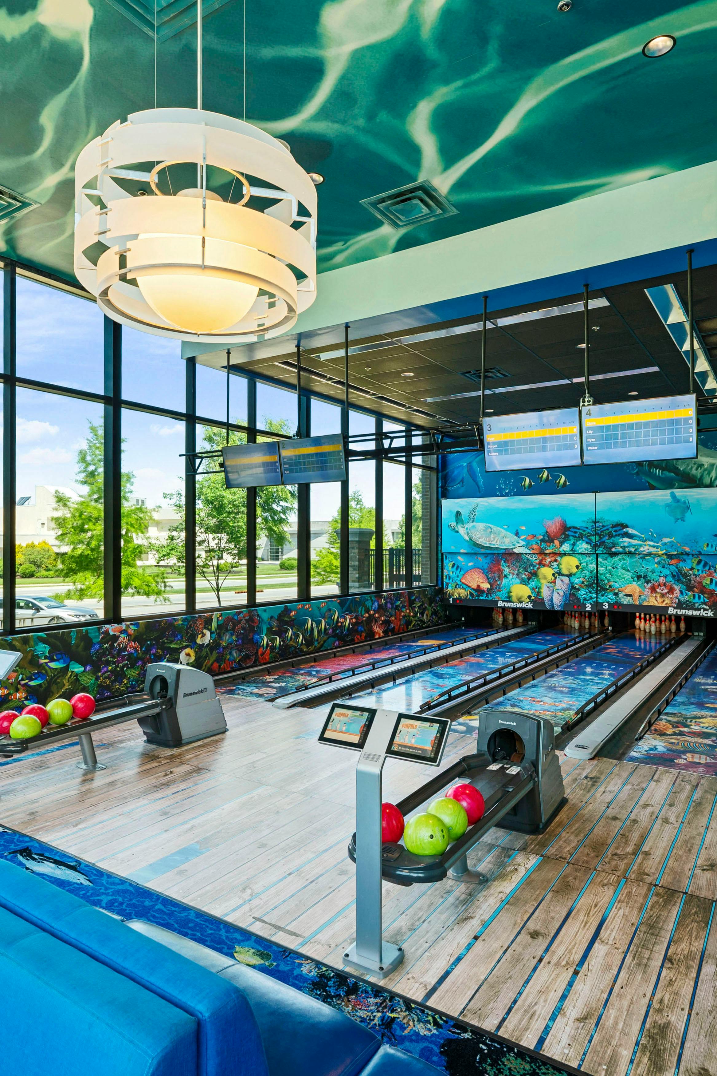 Bowling alley with ocean-themed decor, including murals and lane patterns