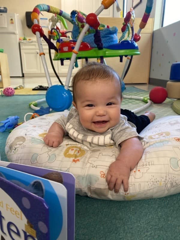 Child on a patterned pillow on the floor