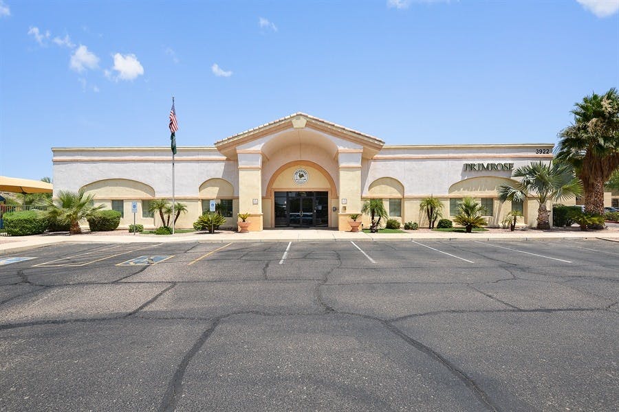 Exterior of a building with a large entrance and a parking lot in front
