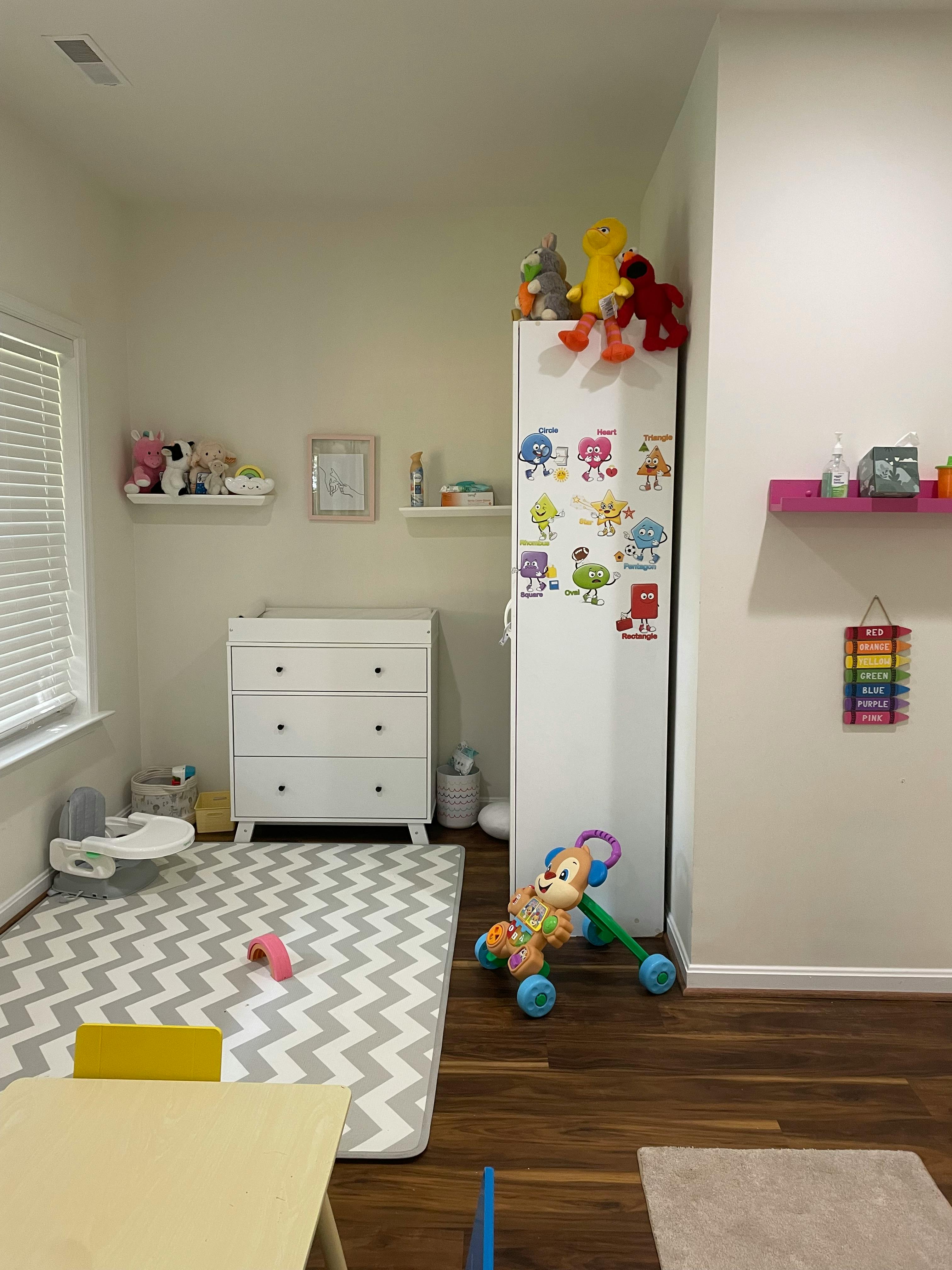 A child's room with a dresser, shelves, and toys