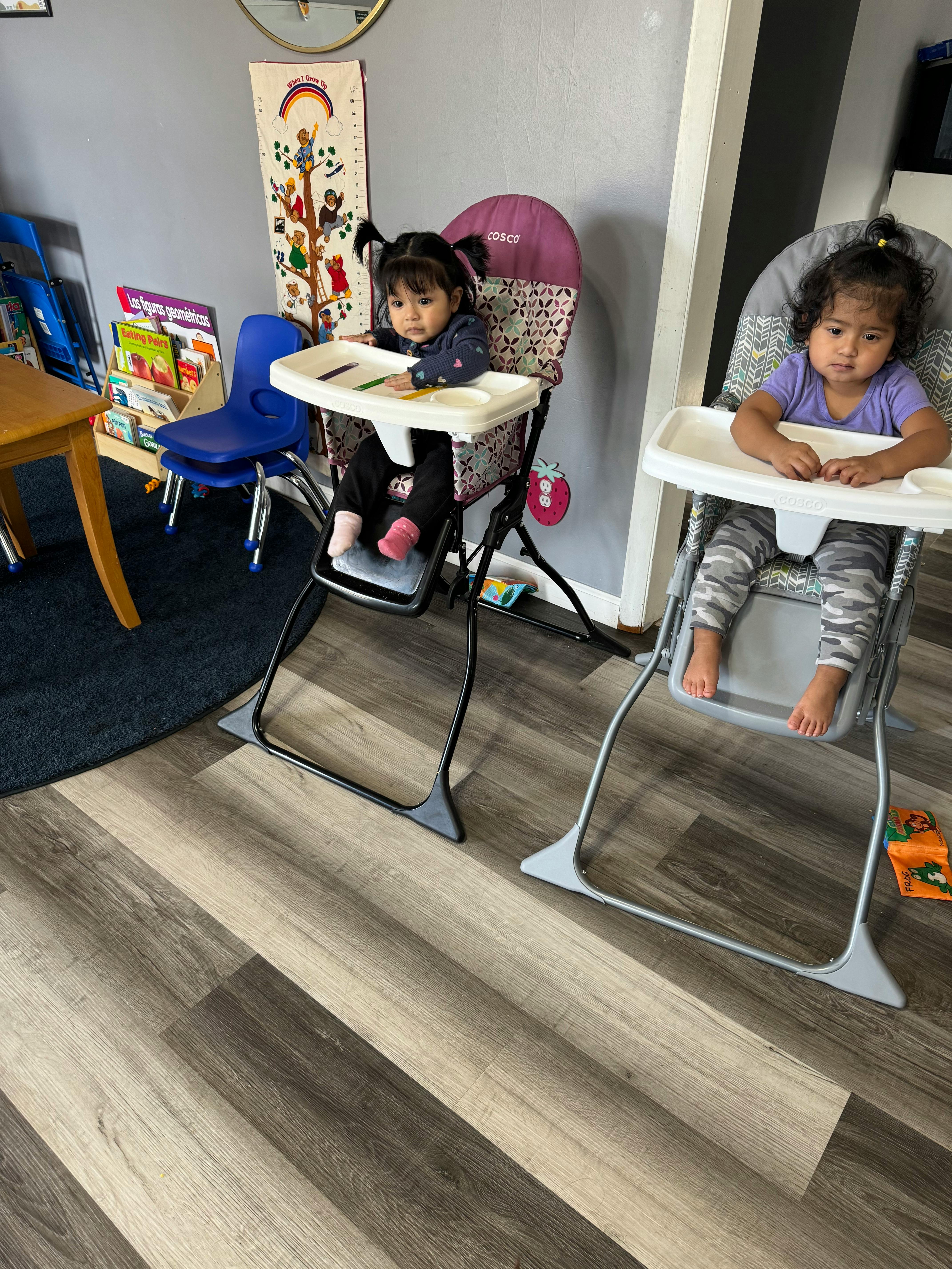 Two children sitting in high chairs