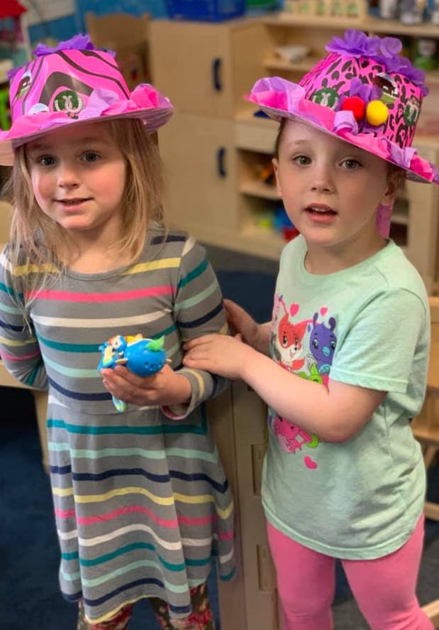 Two children wearing decorated hats