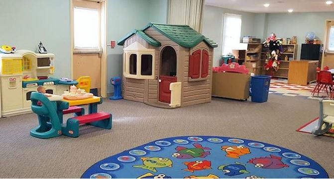 Playroom with a playhouse, toy kitchen, and child-sized table and chairs