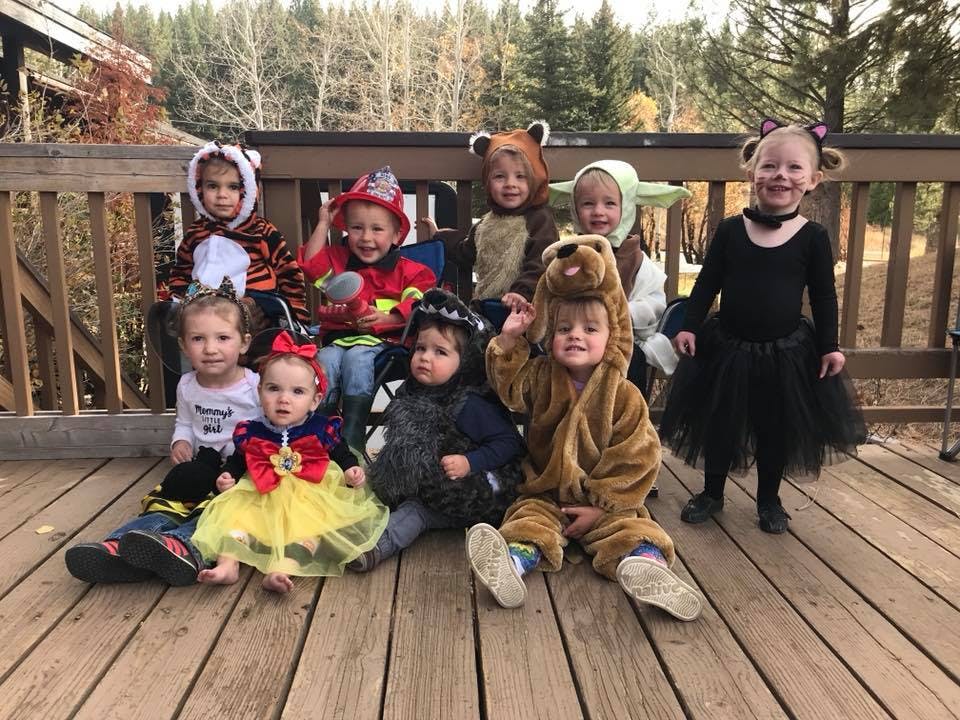 Group of children in various costumes on a wooden deck