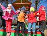 Four children jumping on a playground