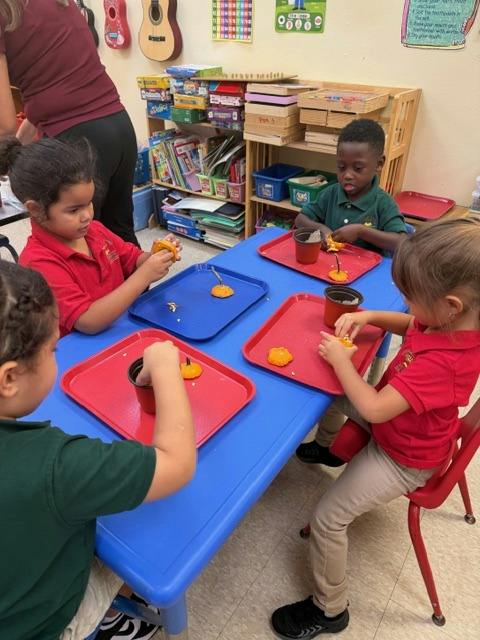 Children working on an art project with small gourds in a classroom