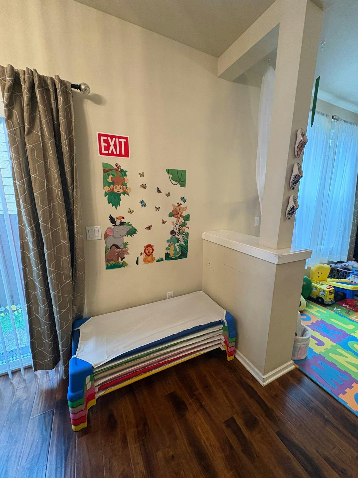 Stacked cots next to a wall with an EXIT sign and animal decals