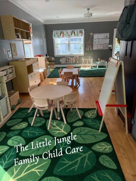 Child care classroom with small tables and chairs, green leaf-patterned rug