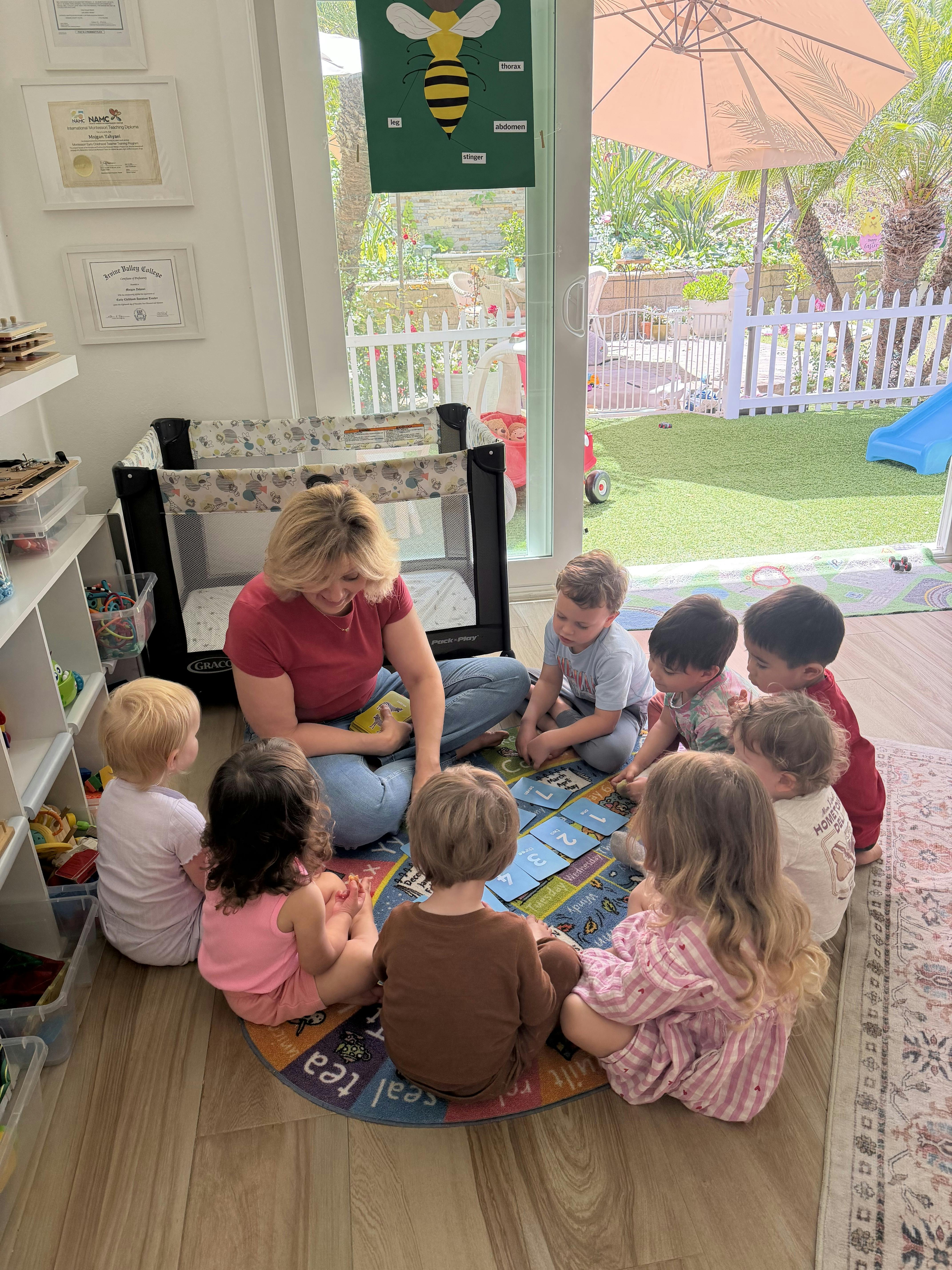 Adult leading a group of children sitting in a circle on a rug