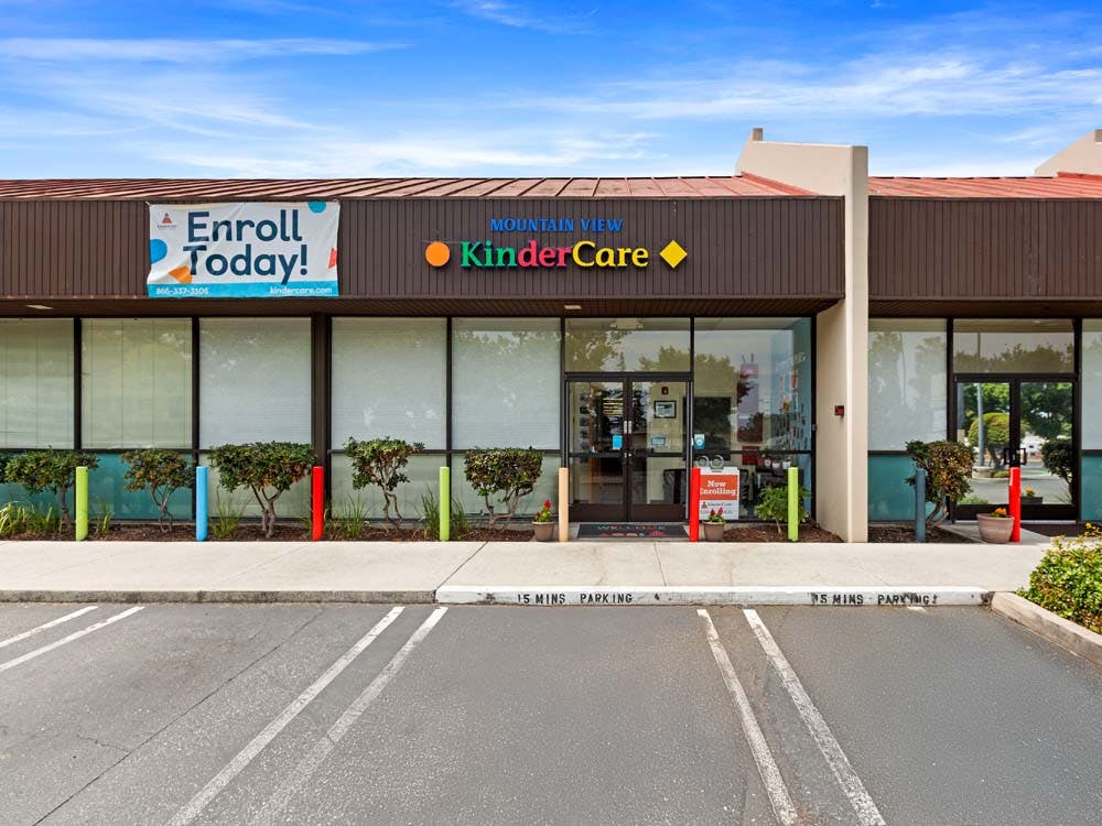 A storefront with "Mountain View KinderCare" sign and "Enroll Today!" banner