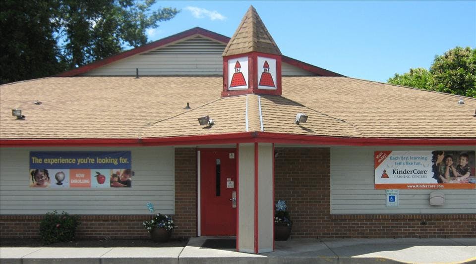 front of a KinderCare Learning Centers building with signs for-rent banners