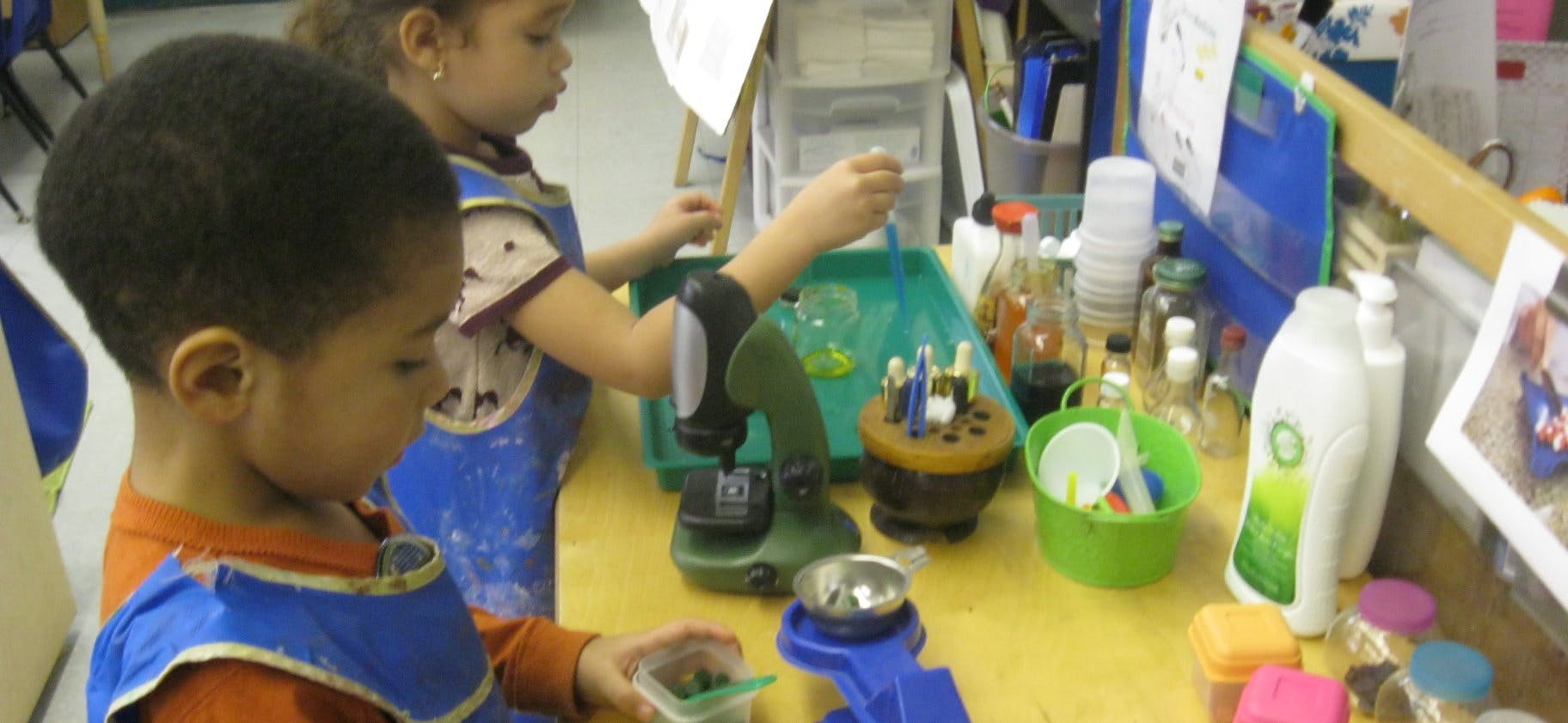 Two children playing with objects on a table