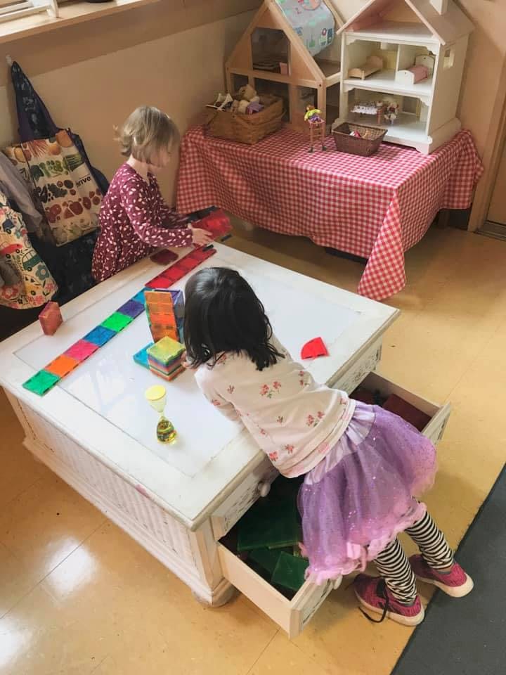Two children playing with toys at a table