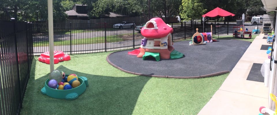 Outdoor playground with play structures and artificial turf