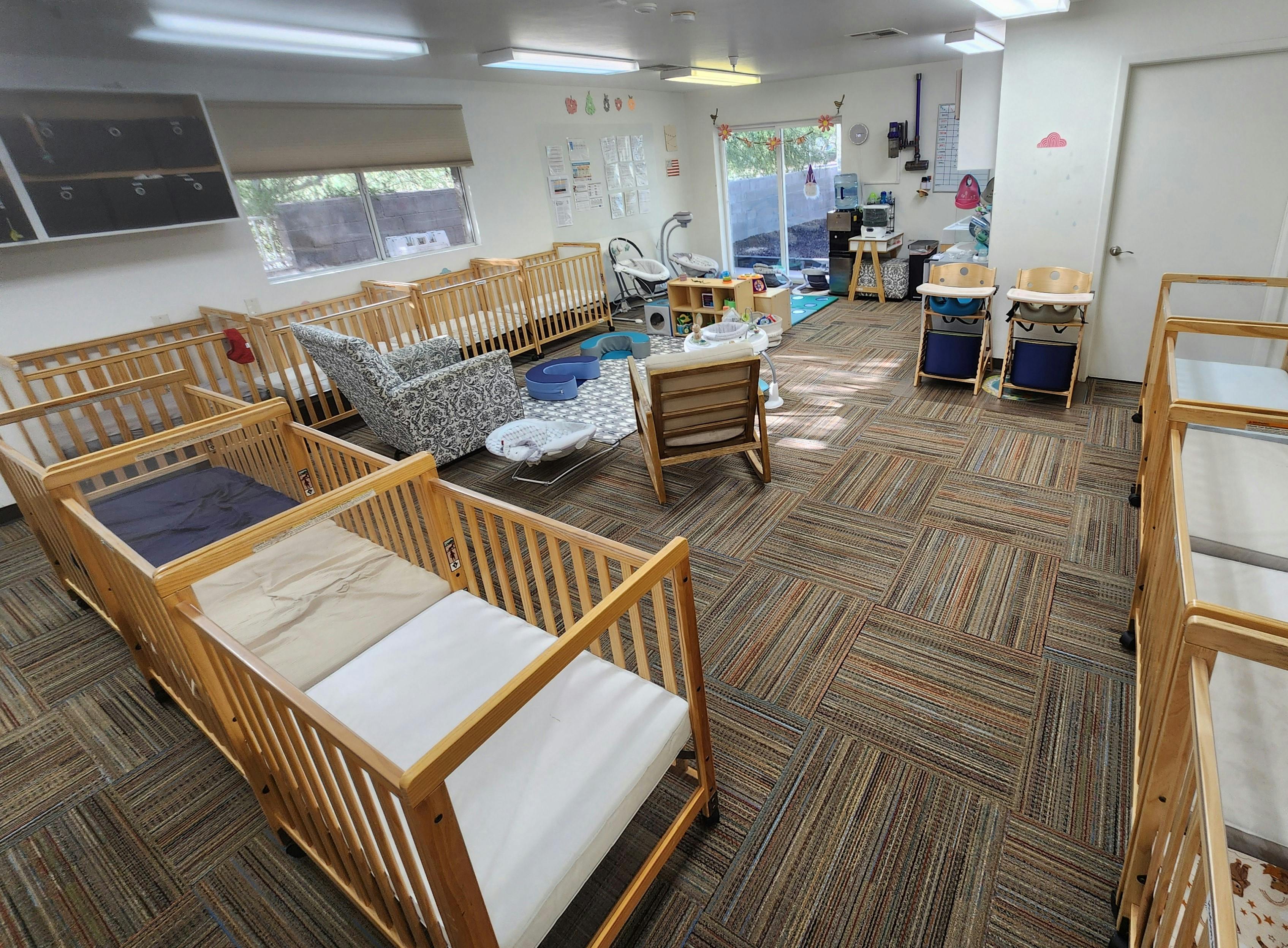 Room with multiple cribs and infant furniture