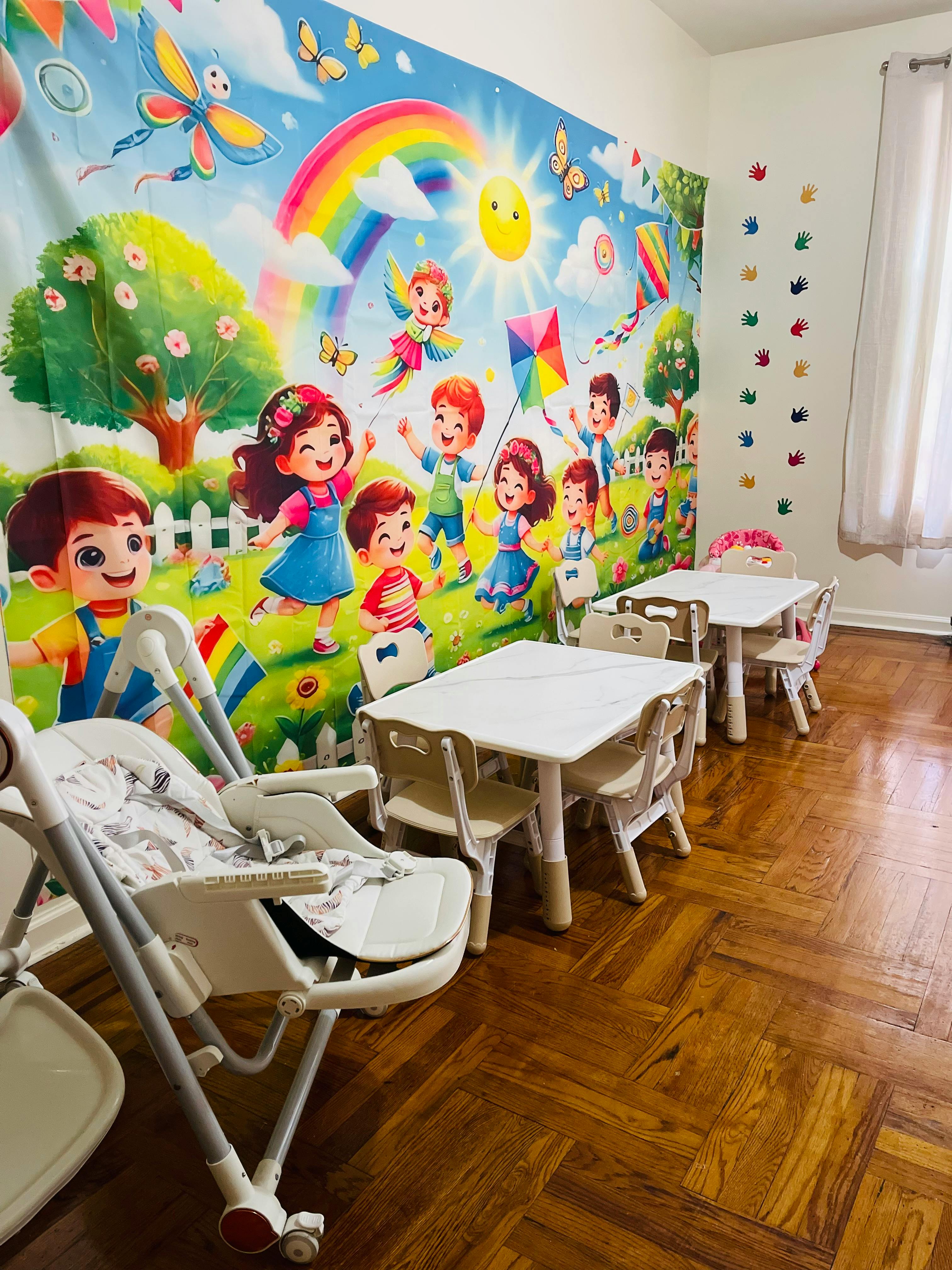 Children's play area with small tables and chairs, and a colorful mural