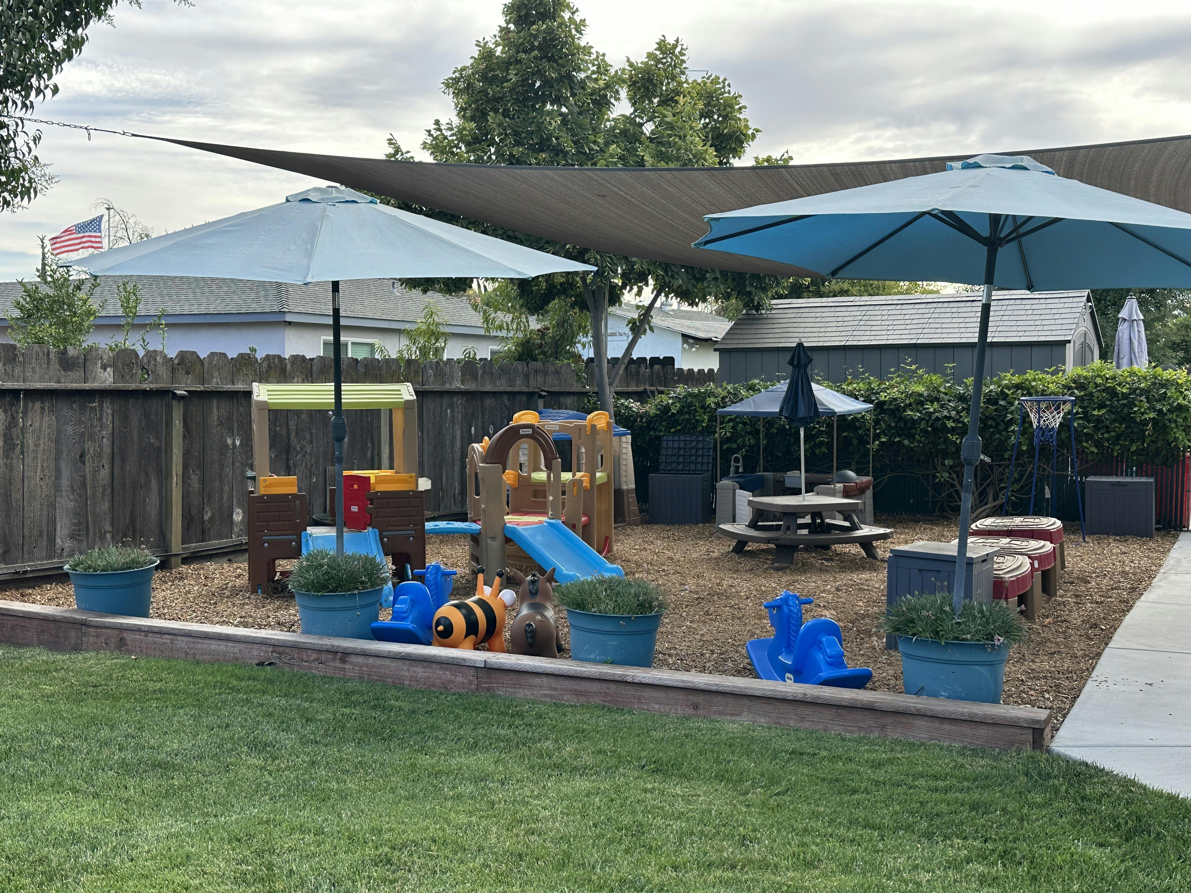 Outdoor playground with slides, umbrellas, and picnic table
