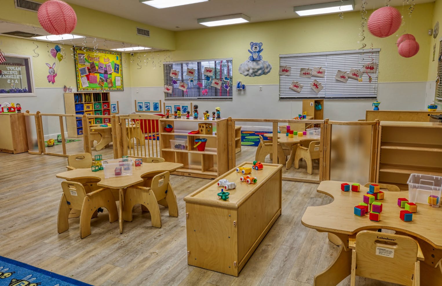Empty colorful preschool classroom with small tables and chairs